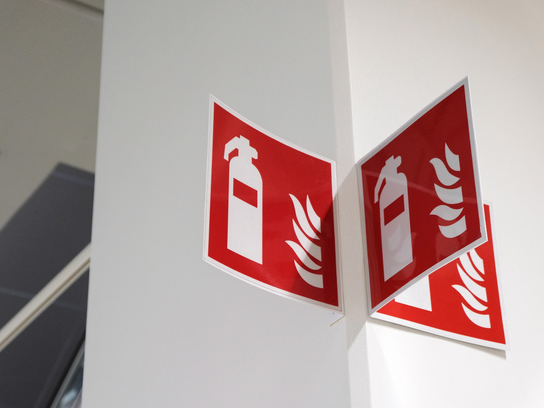fire-extinguisher-sign-on-the-white-wall-136951219