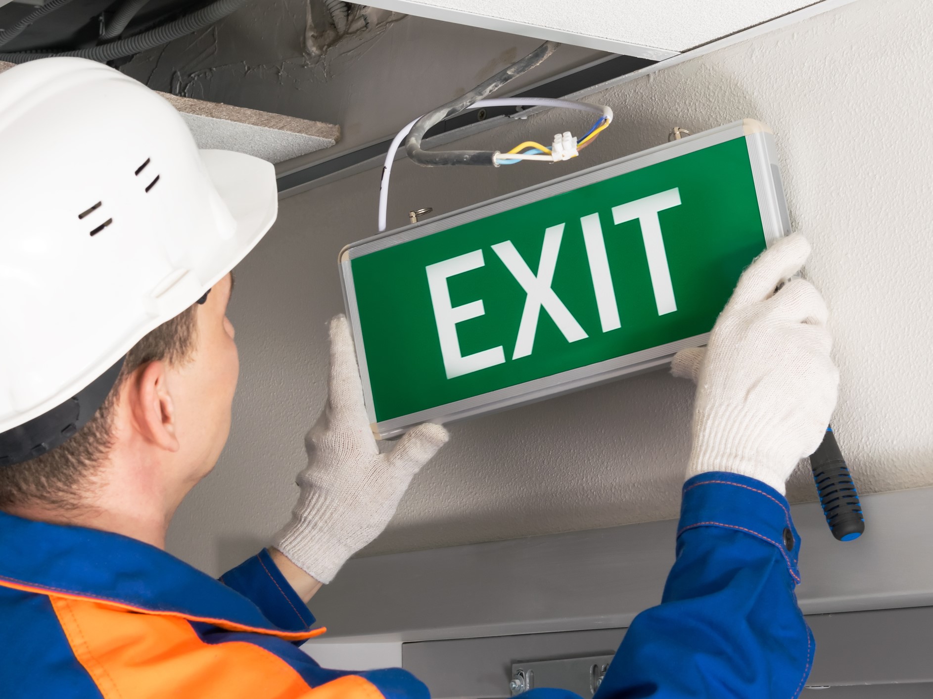 foreman-completes-installation-of-lighting-signs-emergency-exit-218890272