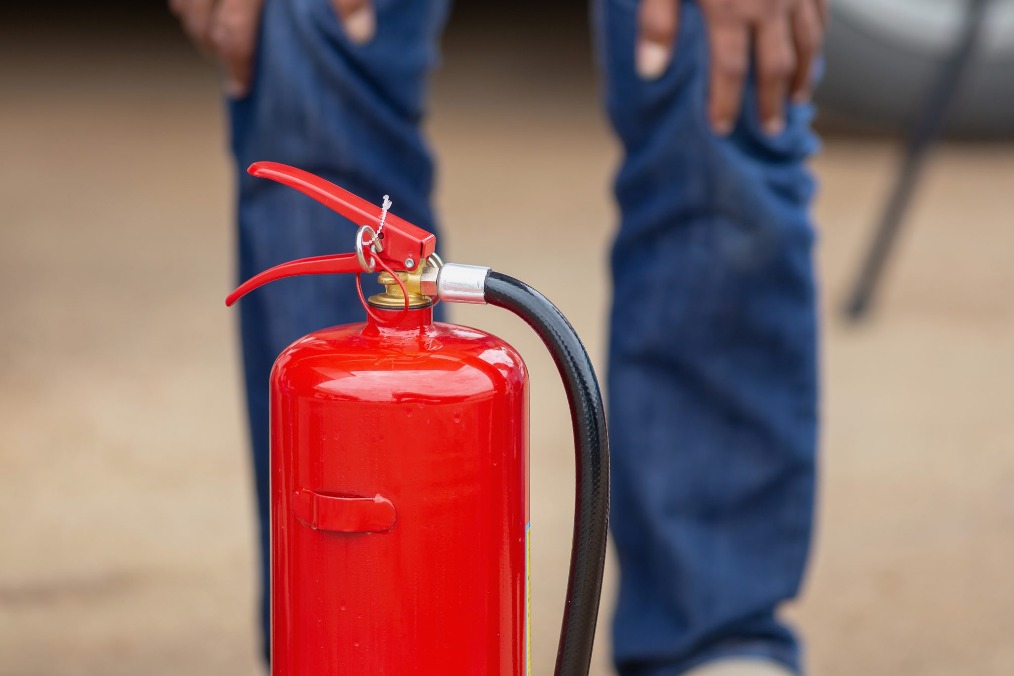instructor-showing-how-to-use-a-fire-extinguisher-on-a-training-124946554